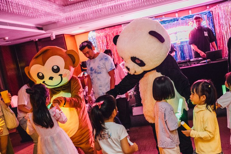 Children gathering around monkey and panda mascots on the Vol. 2 dance floor