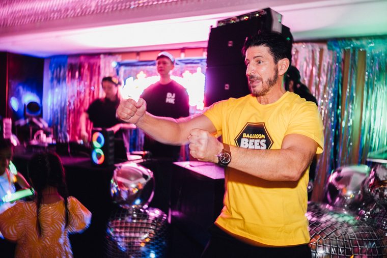 Bubbles floating around a man in a yellow T-shirt beside the dance floor