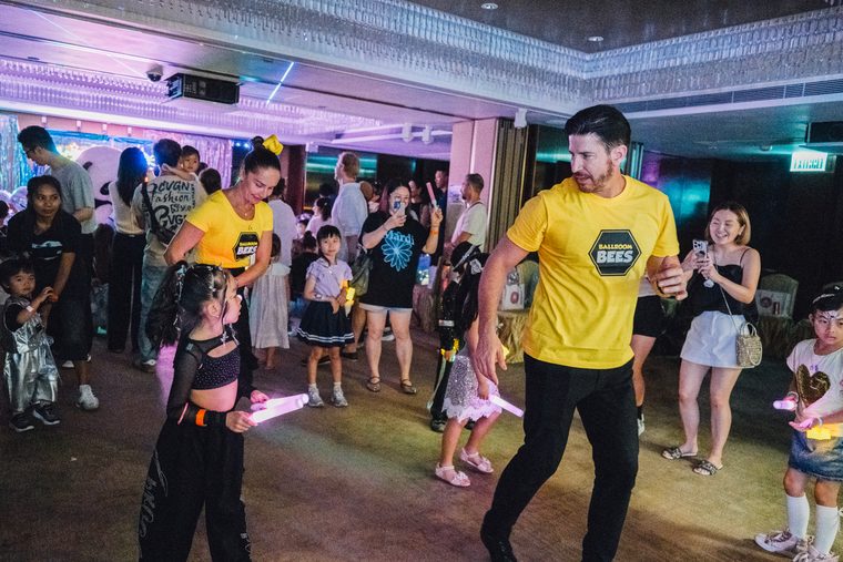 Children and grown-ups joining in a dance activity at Neon Carnival