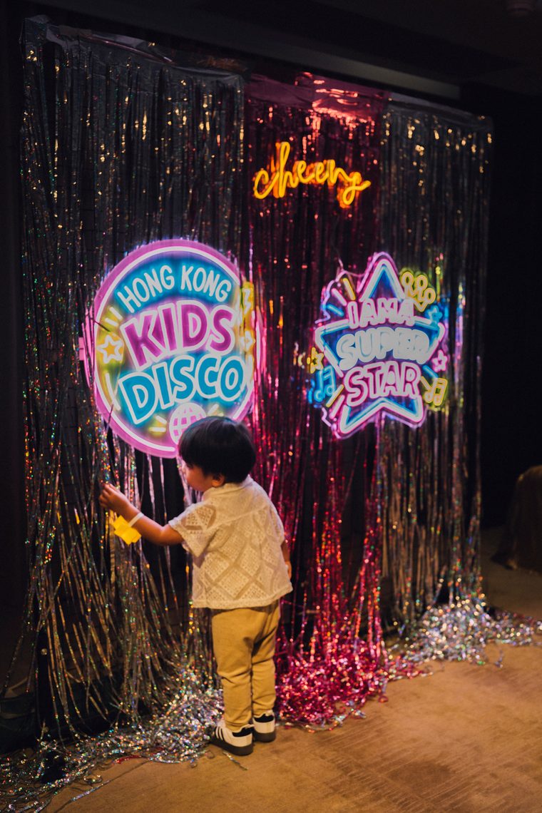 A child exploring the colourful Hong Kong Kids Disco photo backdrop