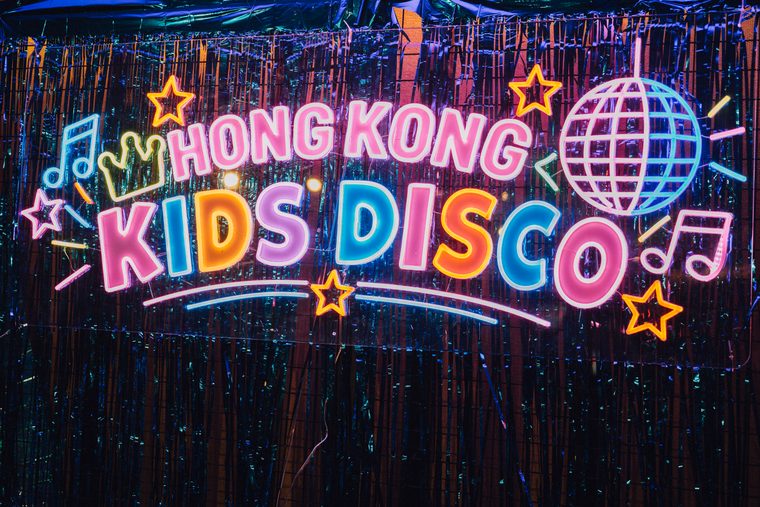 The neon Hong Kong Kids Disco sign against a sparkling tinsel backdrop