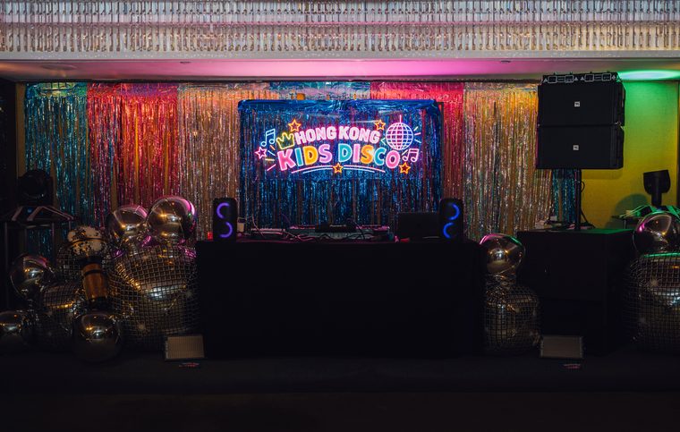 The Neon Carnival party room with its illuminated stage and disco decorations